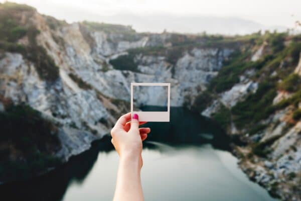 Paper picture frame against a view of mountains and water