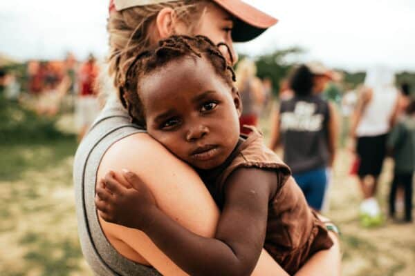Woman holding a baby in a charity video
