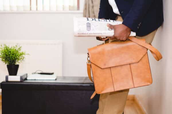 Business man holding the newspaper and a briefcase