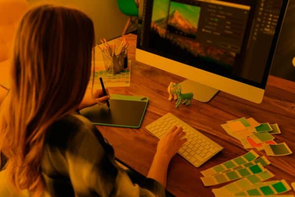 Animated woman editing images on a large computer screen