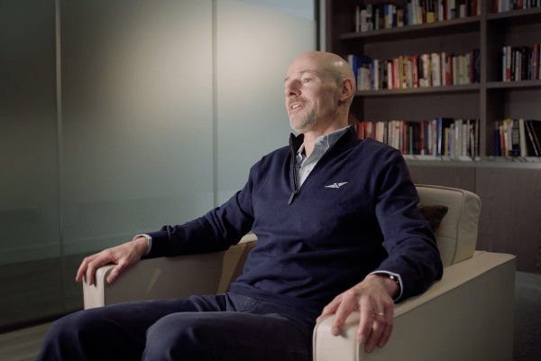 man sat in an arm chair being interviewed