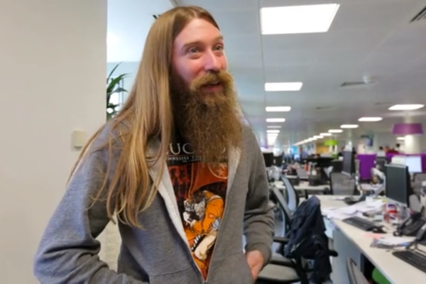 Man with long hair in an office giving an interview