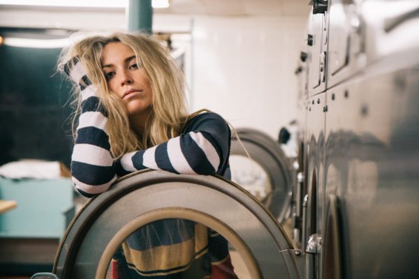 Woman looking bored and doing laundry