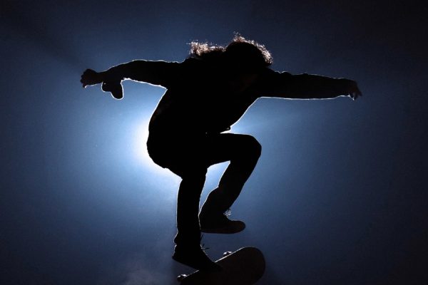 Man jumping on a skateboard in a dark place