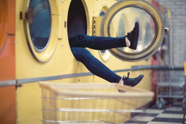 Woman's legs coming out of a washing machine