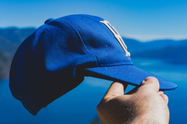 Man holding a blue cap
