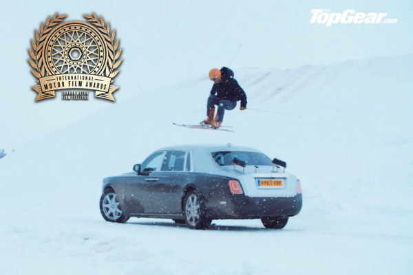 Man doing a jump over a car on skiis for Top Gear