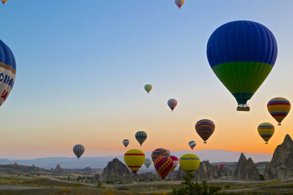 Hot air balloons taking off at sunset