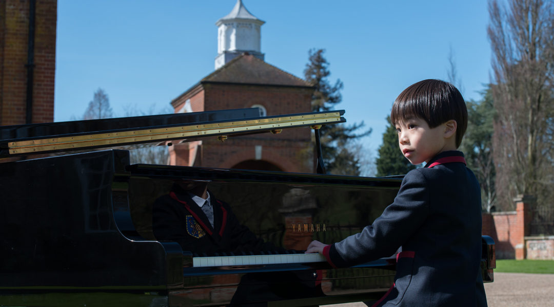 Young child playing the piano in front of a church