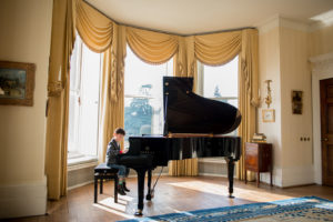 Young child playing the piano in the living room