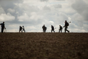 Men using a metal detector in a field