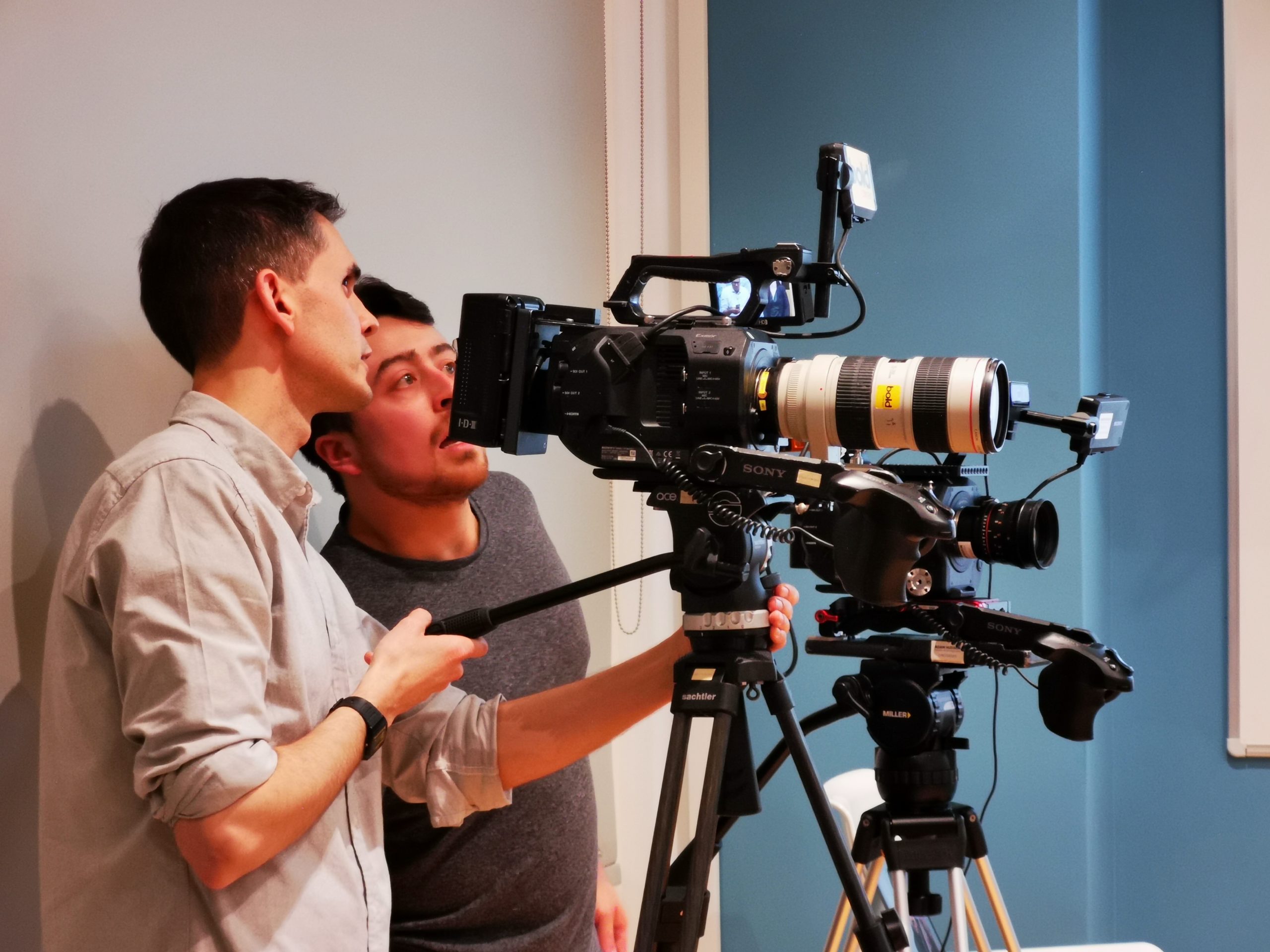two cameramen using a camera on a shoot
