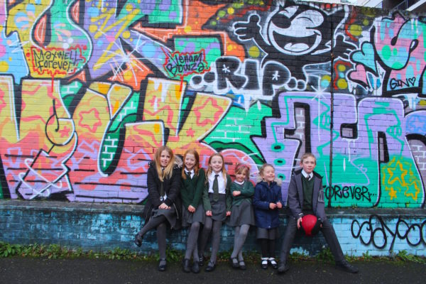 Children outside graffiti wall