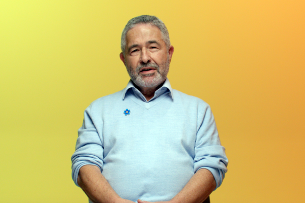 Man talking to camera with a yellow gradient background