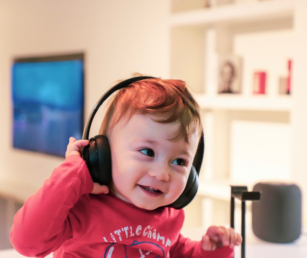 A picture of a smiling baby with headphones on